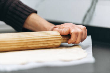 Frau rollt flachen Pizzateig aus - AMAF00018