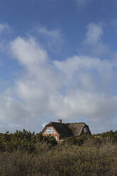 Denmark, Romo, Clouds over rustic house with thatched roof - ASCF01188