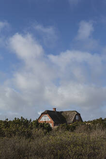 Dänemark, Romo, Wolken über rustikalem Haus mit Strohdach - ASCF01188