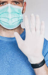Portrait of man wearing mask and protective gloves - JCMF00495