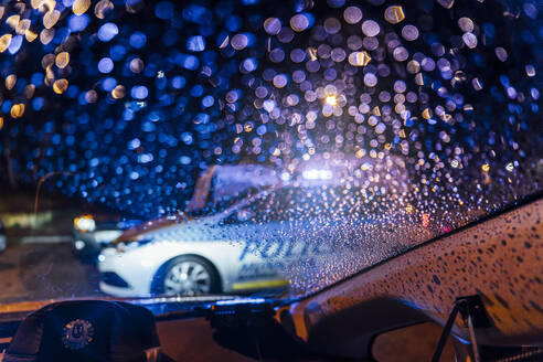 Spanien, Madrid, Innenraum eines Autos, das nachts vor einem Streifenwagen der Polizei geparkt ist - OCMF01151