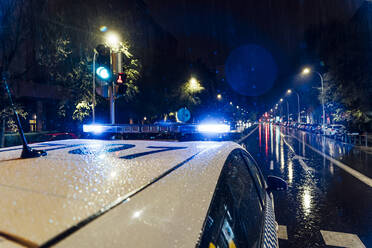 Spanien, Madrid, Dach eines Polizeiautos mitten in der regnerischen Nacht - OCMF01156