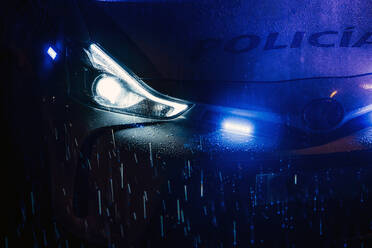 Spanien, Madrid, Kapuze eines Polizeiautos mitten in der regnerischen Nacht - OCMF01160
