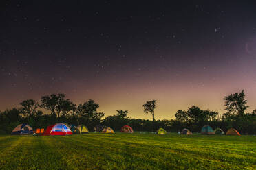 Zelte auf Grasfeld gegen Sternenfeld bei Nacht - EYF01804