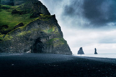 Scenic View Of Rock Formations On Beach Against Cloudy Sky - EYF01837