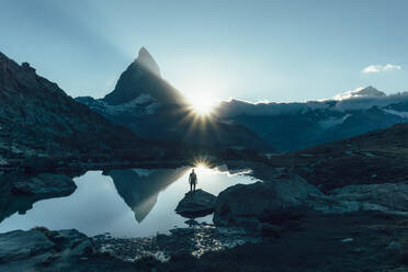 High Angle View Of Man Standing On Rock In See - EYF01843