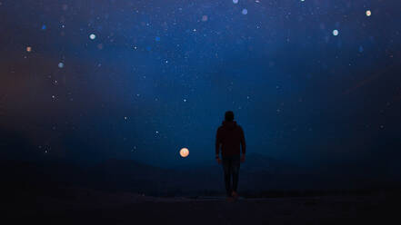 Rückansicht des Mannes zu Fuß gegen den Himmel in der Nacht - EYF01861