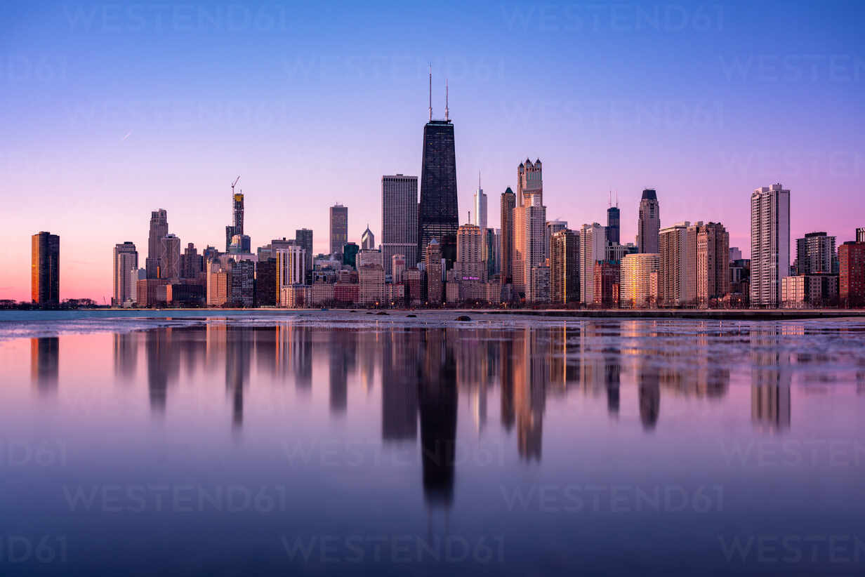 Reflection Of Buildings In City Against Sky During Sunset stock photo