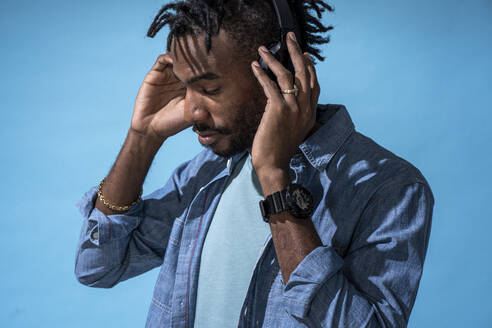 Portrait of stylish young man listening to music with headphones - VPIF02204