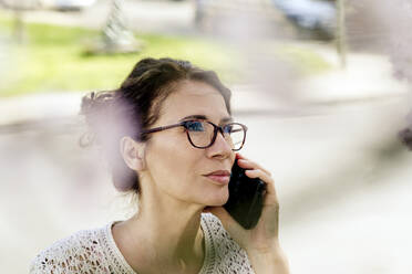 Porträt einer reifen Frau beim Telefonieren im Freien - FLLF00441