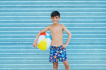 Porträt eines lächelnden Jungen mit Strandball - JCMF00506