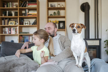 Vater, kleine Tochter und ihr Hund verbringen Zeit zusammen auf der Couch - VYF00088