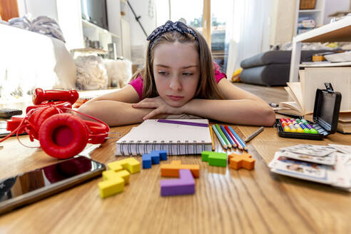 Bored girl lying on floor with play equipment - SARF04498