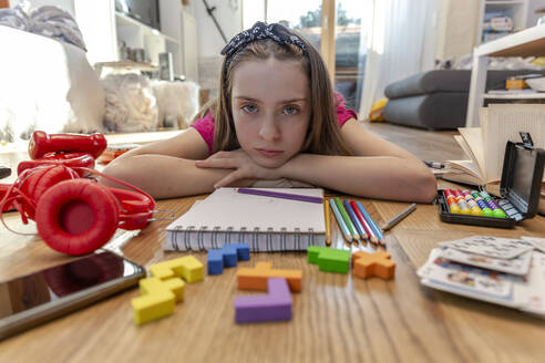 Bored girl lying on floor with play equipment - SARF04499