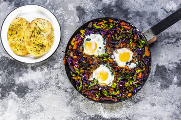 Pan of beetroot shakshouka with chard, carrots, tomatoes, red cabbage and pita bread - SARF04503