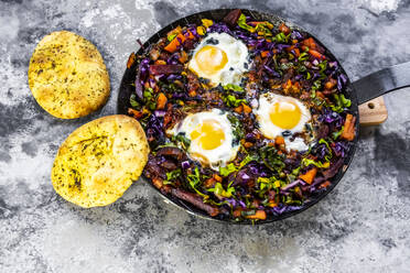 Pan of beetroot shakshouka with chard, carrots, tomatoes, red cabbage and pita bread - SARF04505