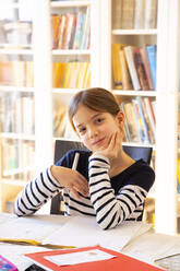 Portrait of smiling girl doing homework - LVF08708