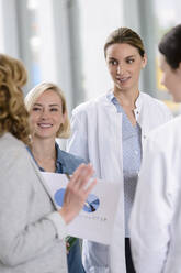 Geschäftsfrau und Ärztinnen bei einem Arbeitstreffen im Krankenhaus - BMOF00349