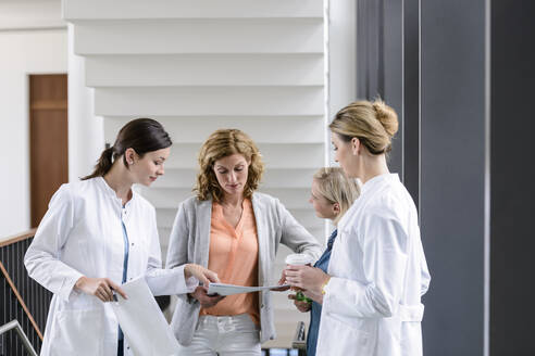 Businesswoman and female doctors having a work meeting in hospital - BMOF00351