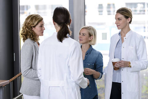 Businesswoman and female doctors talking in hospital stock photo