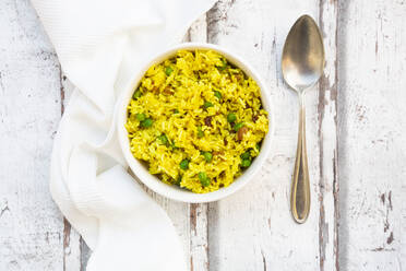 Bowl of pilau rice with green peas, raisins and turmeric - LVF08721