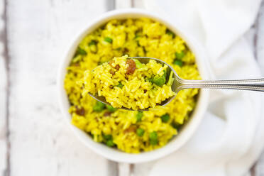 Spoon of pilau rice with green peas, raisins and turmeric - LVF08723