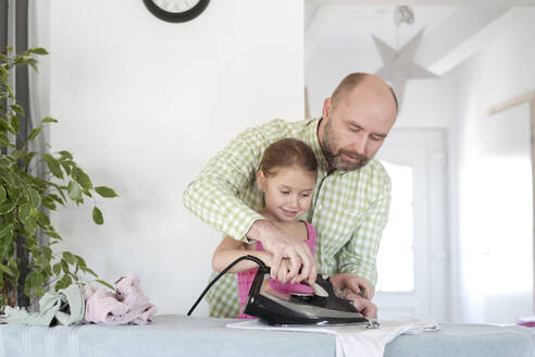 Vater und Tochter bügeln gemeinsam zu Hause - VYF00098