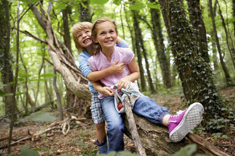 Kinder umarmen sich im Wald, lizenzfreies Stockfoto