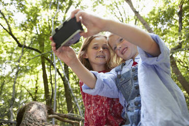 Girls taking selfie with retro camera in forest - AUF00208