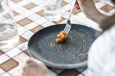 Woman eating last pasta from plate - WPEF02748