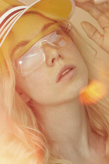 Portrait of young woman wearing glasses and sun visor - PGCF00073