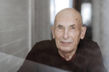 Portrait of smiling old man looking out of window - EYAF01002