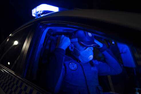 Polizist auf Notfalleinsatz, Gesichtsmaske aufsetzen - OCMF01162