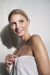 Portrait of smiling beautiful woman wrapped in a towel - PNEF02542