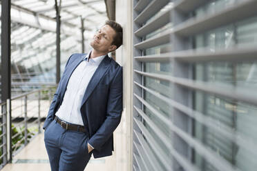 Businessman relaxing with eyes closed, leaning on wall - JOSEF00138