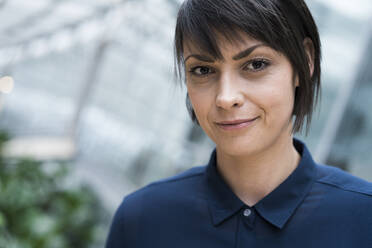 Portrait of smiling businesswoman in sustainable office building - JOSEF00245