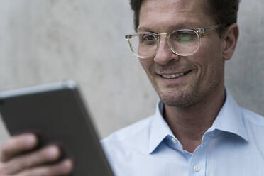Confident businessman using digital tablet - JOSEF00248