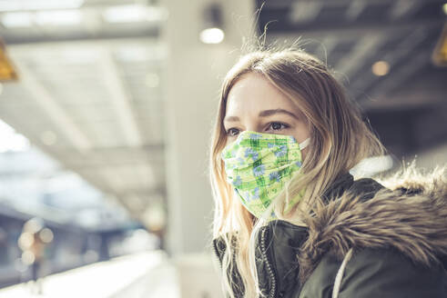 Portrait of young woman wearing mask at station platform - BFRF02208