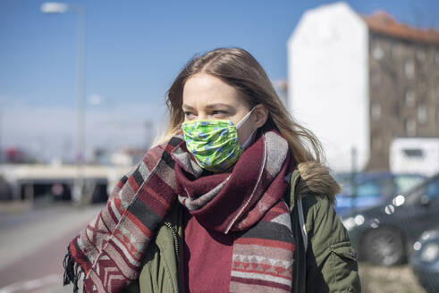Porträt einer jungen Frau mit Maske in der Stadt - BFRF02211