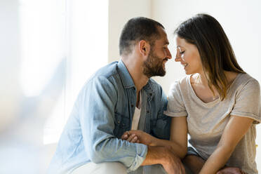 Affectionate smiling couple in love with closed eyes at home - SBOF02185