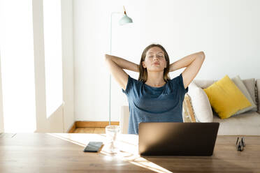 Young woman at home relaxing and having a break from working at laptop in home office - SBOF02227