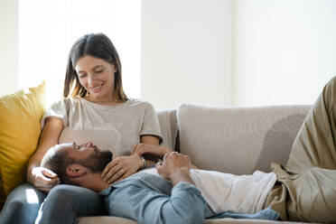 Verliebtes junges Paar entspannt sich auf der Couch zu Hause - SBOF02278