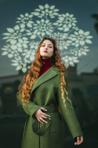 Portrait of redheaded young woman wearing fashionable green coat stock photo