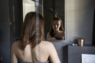 Mirror image of pensive girl in bathroom - AUF00234