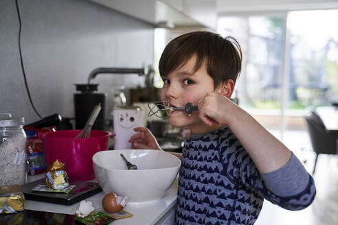 Porträt eines Jungen, der in der Küche Teig probiert - AUF00244