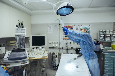 Doctor preparing IV drip in trauma room of a hospital - MFF05251