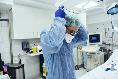 Arzt, der die ffp2-Maske in der Notaufnahme eines Krankenhauses anlegt - MFF05260