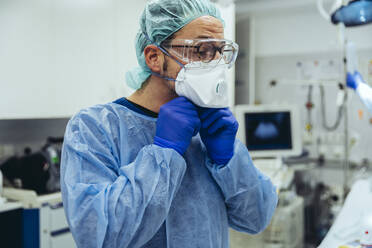Arzt, der die ffp2-Maske in der Notaufnahme eines Krankenhauses anlegt - MFF05261