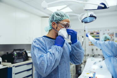 Arzt, der die ffp2-Maske in der Notaufnahme eines Krankenhauses anlegt - MFF05262