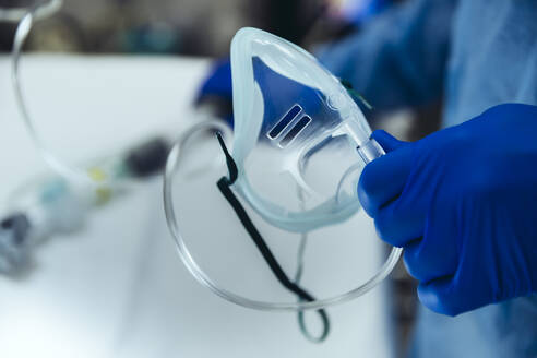 Close-up of emergeny doctor holding an oxygen mask in hospital - MFF05277